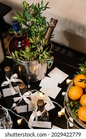 A Bottle Of Sparkling Wine And Aperol Are Chilled In An Ice Bucket. No Labels Are Visible. Bottles Are Covered With Beautiful Green Twigs