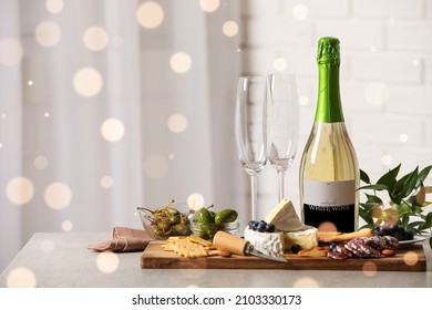 Bottle of sparkling wine, glasses and delicious snacks on grey table indoors. Space for text - Powered by Shutterstock