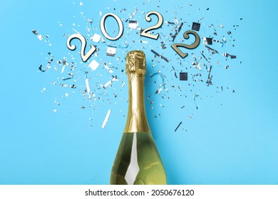 Bottle Of Sparkling Wine, Shiny Confetti And Number 2022 On Light Blue Background, Flat Lay. Happy New Year