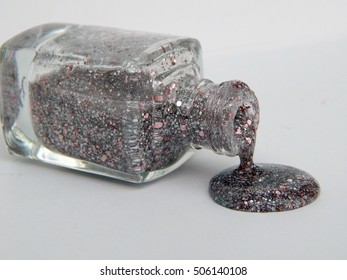 Bottle With Spilled Glitter Nail Polish On White