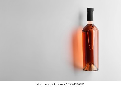 Bottle of tasty wine on light background