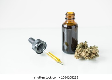 A Bottle Of Tincture With A Dropper And Cannabis Bud Demonstrating It`s Contents