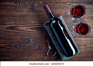 Bottle And Two Glasses Of Red Wine On Wooden Background From Top View