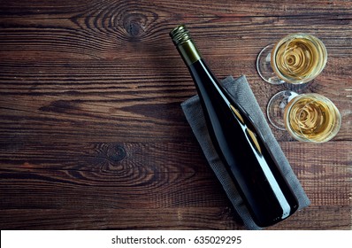 Bottle And Two Glasses Of White Wine On Wooden Background From Top View