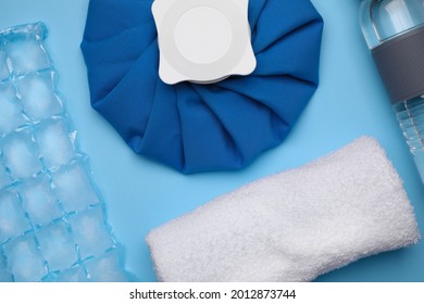 Bottle Of Water, Cold Compress, Ice Pack And Towel On Light Blue Background, Flat Lay. Heat Stroke Treatment