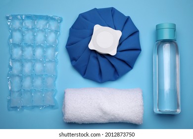 Bottle Of Water, Cold Compress, Ice Pack And Towel On Light Blue Background, Flat Lay. Heat Stroke Treatment