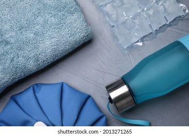 Bottle Of Water, Cold Compress, Ice Pack And Towel On Grey Background, Flat Lay. Heat Stroke Treatment