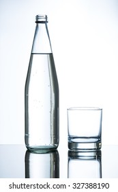 Bottle Of Water And Empty Glass On Glass Table