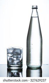 Bottle Of Water And Glass Of Ice On Glass Table