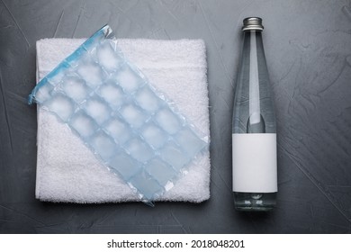 Bottle Of Water, Ice Pack And Towel On Grey Background, Flat Lay. Heat Stroke Treatment