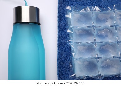 Bottle Of Water, Ice Pack And Towel On White Background, Flat Lay. Heat Stroke Treatment