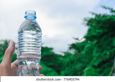 Bottle water made to plastic on sky and tree blurry background.Using wallpaper for package or product, refreshing image and copy space.