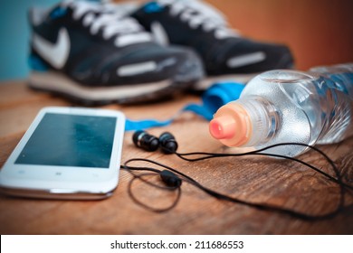 Bottle with water,  smartphone, earphones and sneakers at a background. Set for sports activities - Powered by Shutterstock