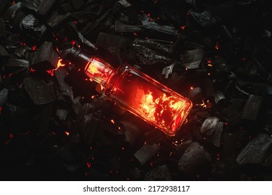 Bottle of whiskey on the blazing charcoals background. Top view. 