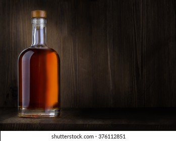 Bottle of whiskey on a wooden background with copy space