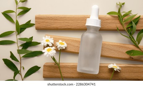 a bottle of white frosted glass for cosmetics with a pipette lies on wooden boards on a plain background. close-up, mockup for your design, blank for advertising, blank for the design of your product