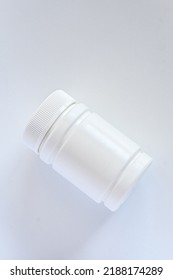 Bottle With A White Pill Or Vitamin Nutritional Supplement, A Plastic Bottle With A Medical Drug On A White Background. View From Above