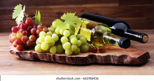 Bottle Of White And Red Wine, Grape And Corks On Wooden Table