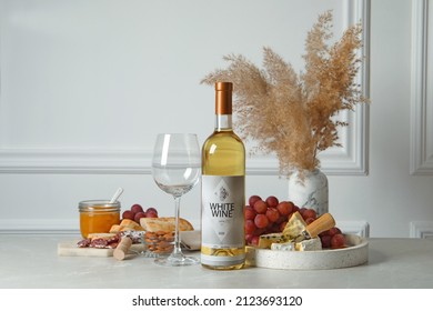 Bottle Of White Wine, Glass And Snacks On Table