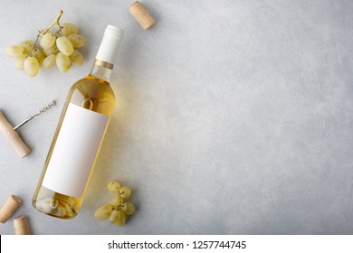 A Bottle Of White Wine With A Label, Grapes, Cork And Bottle Opener. Top View.