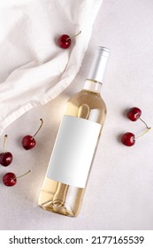 Bottle Of White Wine Mockup With Blank Label And Cherry Berries