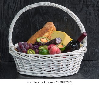 Bottle Of Wine, Cheese, Sausage And Exotic Fruits In A Basket