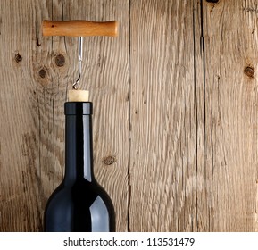 Bottle of wine with corkscrew on wooden background - Powered by Shutterstock