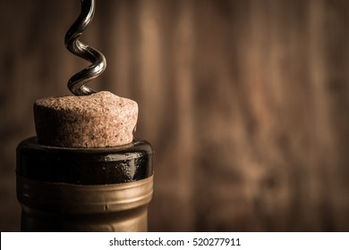 Bottle of wine with corkscrew on wooden background - Shutterstock ID 520277911