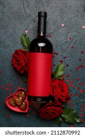 Bottle of wine, roses and chocolate candies for Valentine's Day on dark background