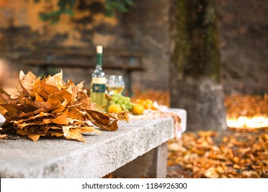 A Bottle Of Wine And Two Glasses, On A Picnic. Autumn Leaves In The Garden. Romantic Party On The Street. Free Space For Text. Copy Space