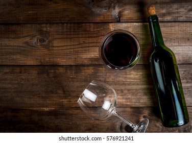 Bottle Of Wine And Two Glasses - One Empty, One Full Poured On A Wooden Table, Top View, Copy Space 