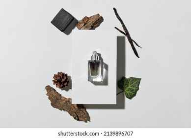 Bottle of woody perfume on light background, top view