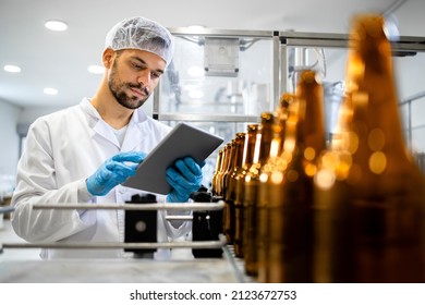 Bottled Beer Beverage Production And Factory Worker Controlling Process On Tablet Computer.