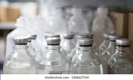 Bottled medical isotonic solution close up, soft focus, blurred background. Row of vials of medical fluids