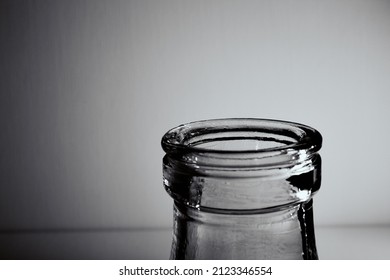 The Bottleneck Of Glass Bottle. Close-up. Copy Space. Graphic Still Life With Light And Shadow In Black And White Colors. Art. Recyclable Materials. Concept Of Alcohol Problems. Depressive Condition.