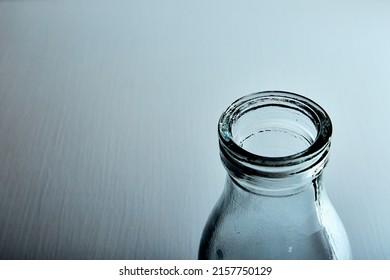 The Bottleneck Of Glass Bottle. Close-up. Copy Space. Graphic Still Life With Light And Shadow In Black And White Colors. Art. Recyclable Materials. Concept Of Alcohol Problems. Depressive Condition.