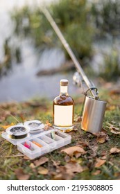 Bottles With Alcohol Drinks Lying On The Grass With Fishing Tackle. Bottle With Blank Label To Copy Paste. Mockup Image For Branding Drink
