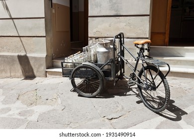 Bottles And Aluminum Cans Of Milk For Delivery In Vintage Rusty Milkman Bicycle.