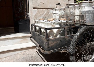 Bottles And Aluminum Cans Of Milk For Delivery In Vintage Rusty Milkman Bicycle.