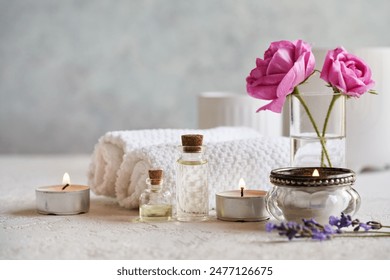 Bottles of aromatherapy essential oil with lavender and rose de Mai flowersand spa treatment accessories on white background with copy space - Powered by Shutterstock