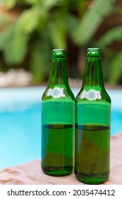 Bottles Of Beer By The Pool. No People. Alcohol At A Summer Party. Tropics, Vacation, Relaxation