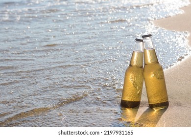 Bottles Of Cold Beer On Sandy Beach Near Sea, Space For Text