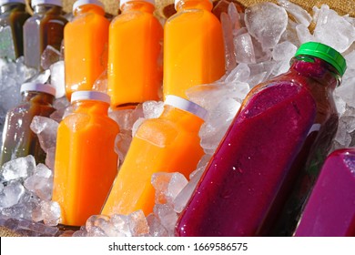 Bottles of colorful cold pressed juice on ice