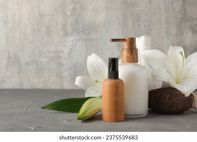 Bottles of cosmetic products, pumice and beautiful lily flowers on grunge background - Powered by Shutterstock