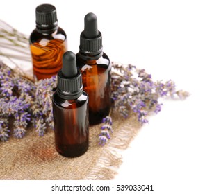 Bottles With Essential Oil And Lavender On White Background