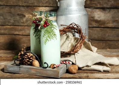 Bottles of fresh milk with natural decor, on wooden background