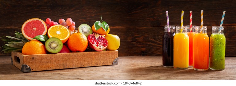 Bottles Of Fruit Juice With Fresh Fruits On A Wooden Table