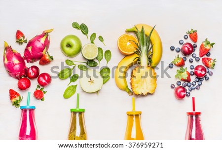 Bottles of Fruits smoothies with various ingredients on white wooden background, top view.  Superfoods and healthy lifestyle or detox  diet food concept.