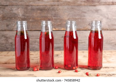 Bottles With Goji Juice On Wooden Table