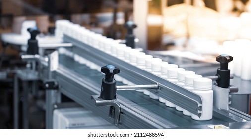 Bottles of medical pill after filling and capping on conveyor. Pharmaceutical industry. - Shutterstock ID 2112488594